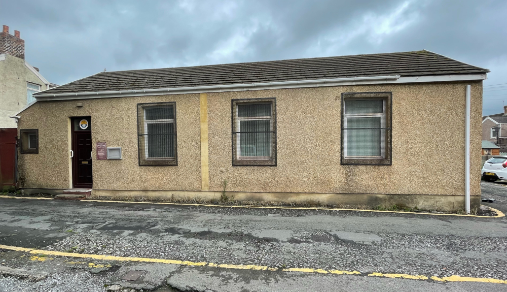 Modern photograph of the former Port Talbot Synagogue today, showing a one-storey building with door and three windows.